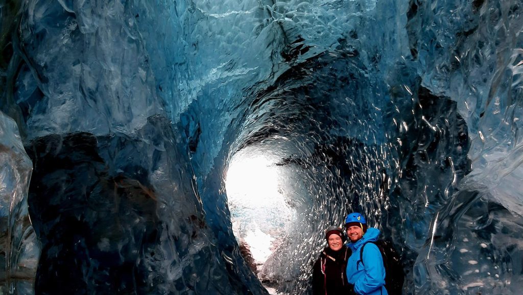 Ice cave explorers in a meltwater tunnel on an Icelandic glacier outlet of Vatnajökull Ice Cap