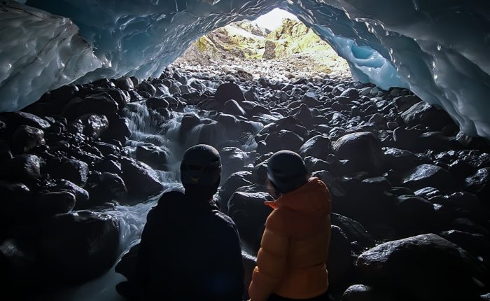 A couple shares a moment in a remote ice cave.